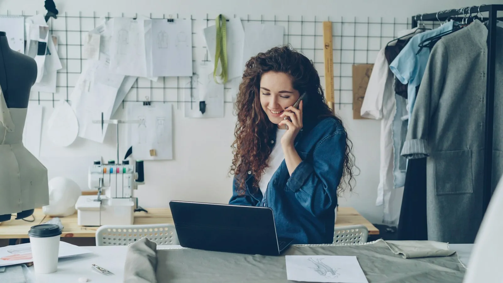 Een zaakvoerder werkt in een atelier, met een laptop en gsm binnen handbereik