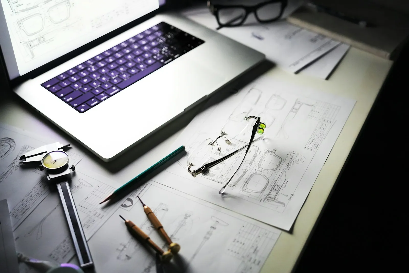 Een ondernemer werkt een onderhoudschecklist af op een laptop, met gereedschap binnen handbereik